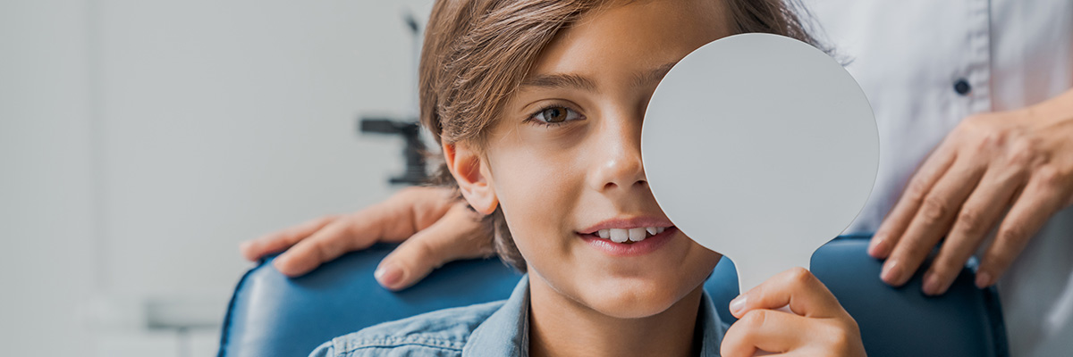 Boy covers left eye